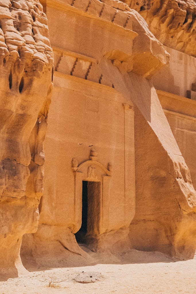 A historic stone tomb entrance carved into the desert rock, showcasing ancient architecture.