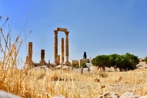 Historic Roman ruins at the Temple of Hercules in Amman with iconic stone columns under clear blue sky.