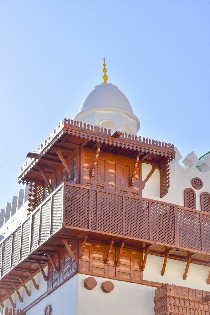 Wooden lattice facade of a traditional Saudi Arabian building under clear blue sky.